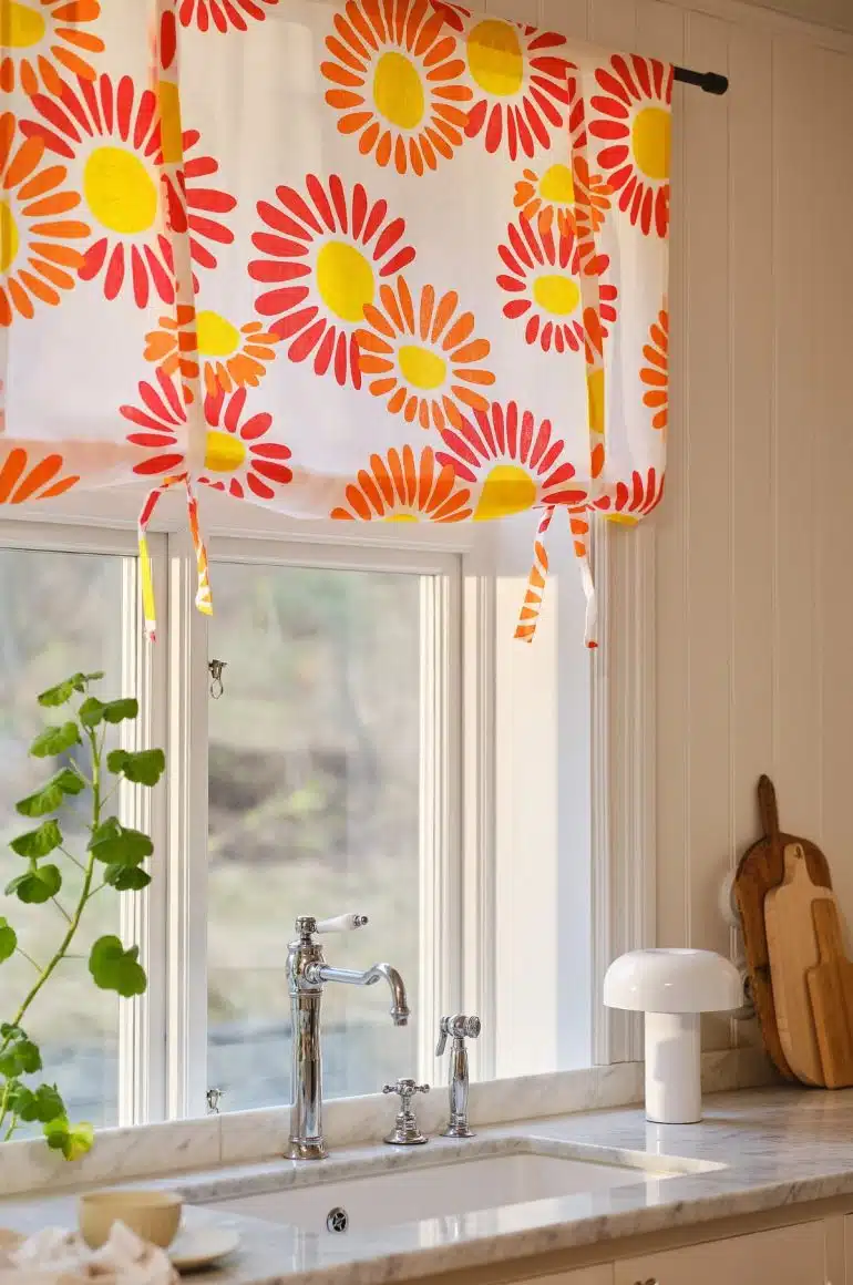 blommig hissgardin i vitt fönster.