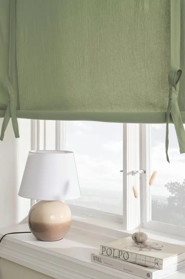 grön hissgardin i vitt fönster