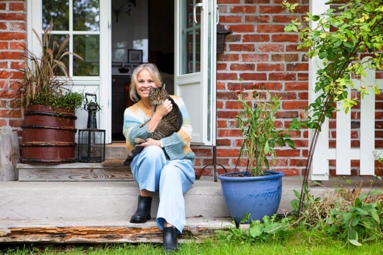 kvinna sitter på trappa med katt